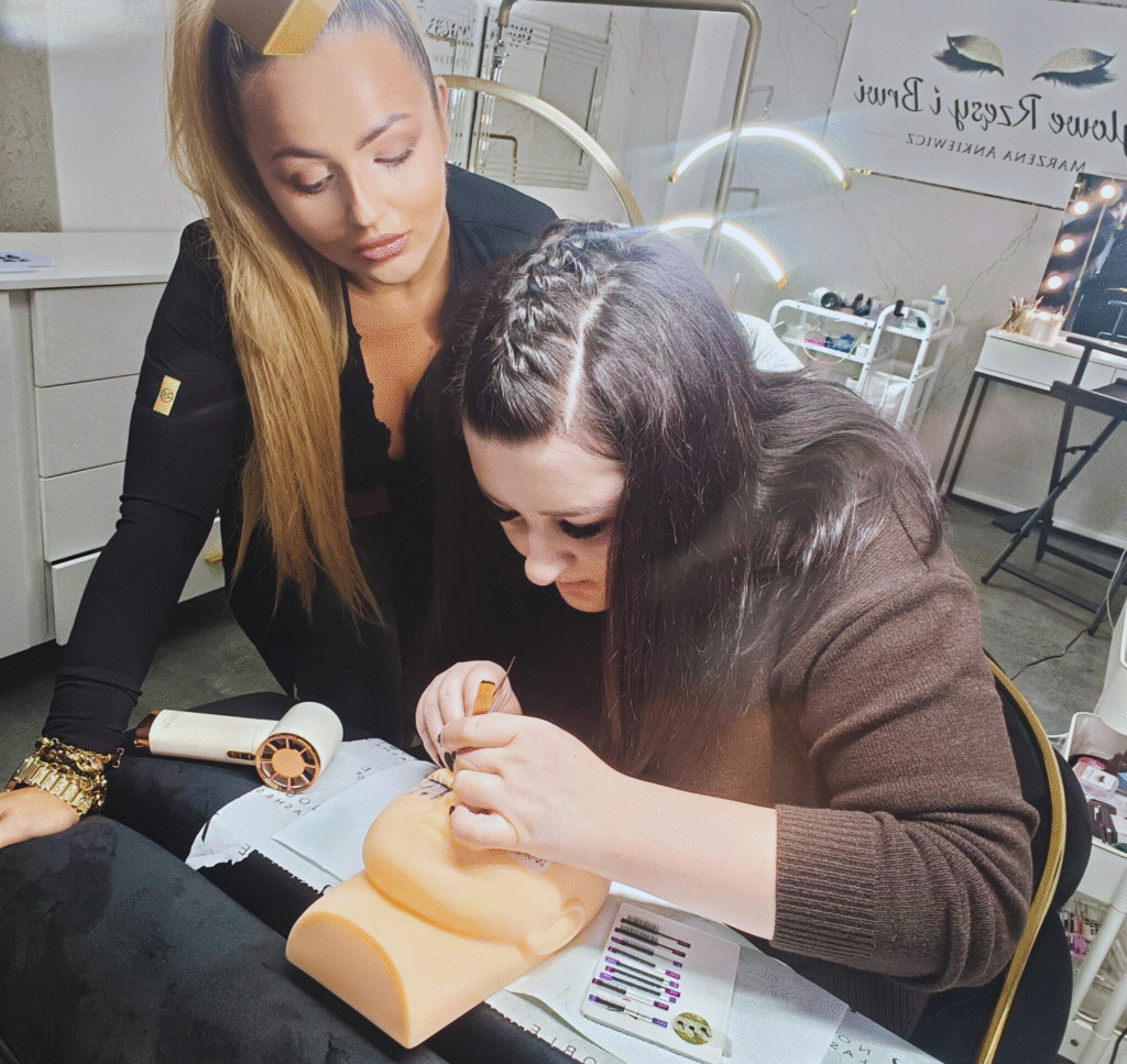 Szkolenie ze stylizacji rzęs w salonie Stylowe Rzęsy i Brwi w Rybniku Boguszowicach. Instruktorka nadzoruje kursantkę ćwiczącą na główce treningowej.